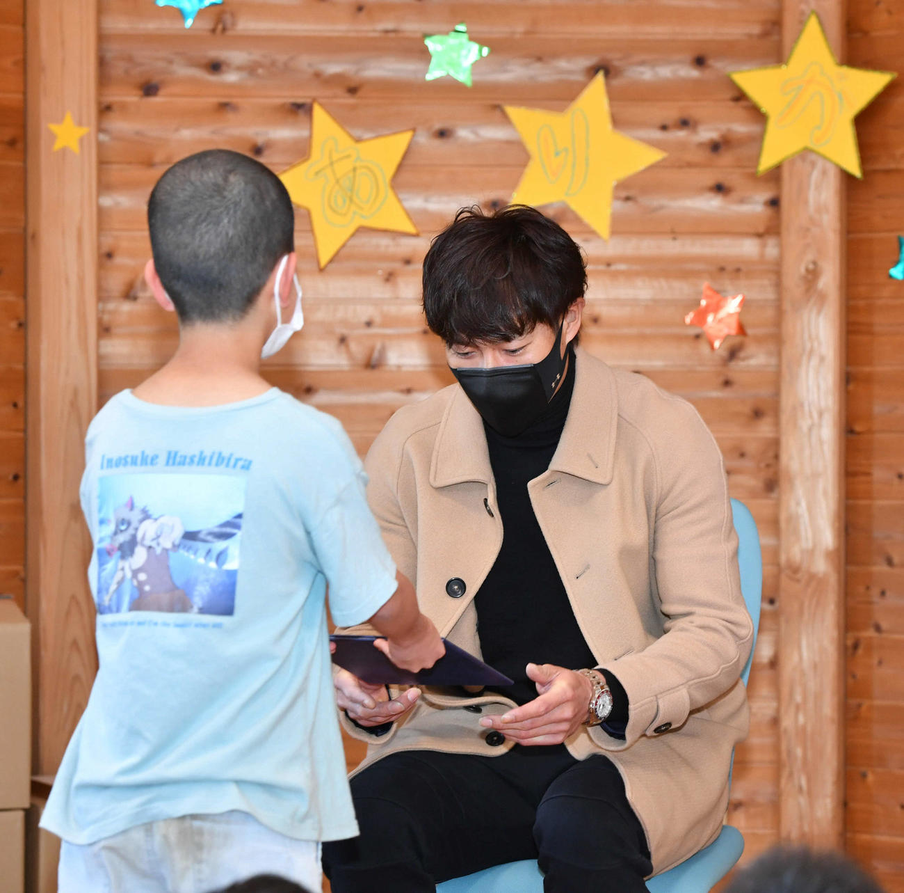SOS子どもの村福岡を訪問し、子どもからプレゼントを受け取る柳田（撮影・岩下翔太）
