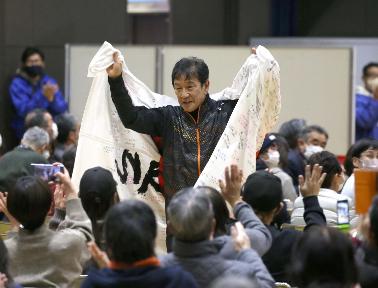 栗山町で行われた「栗さん感謝のつどい」で町民などから贈られた日の丸を羽織り退場する栗山監督（撮影・黒川智章）