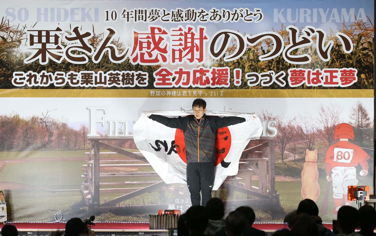 栗山町で行われた「栗さん感謝のつどい」で町民などから贈られた日の丸を羽織る栗山監督（撮影・黒川智章）