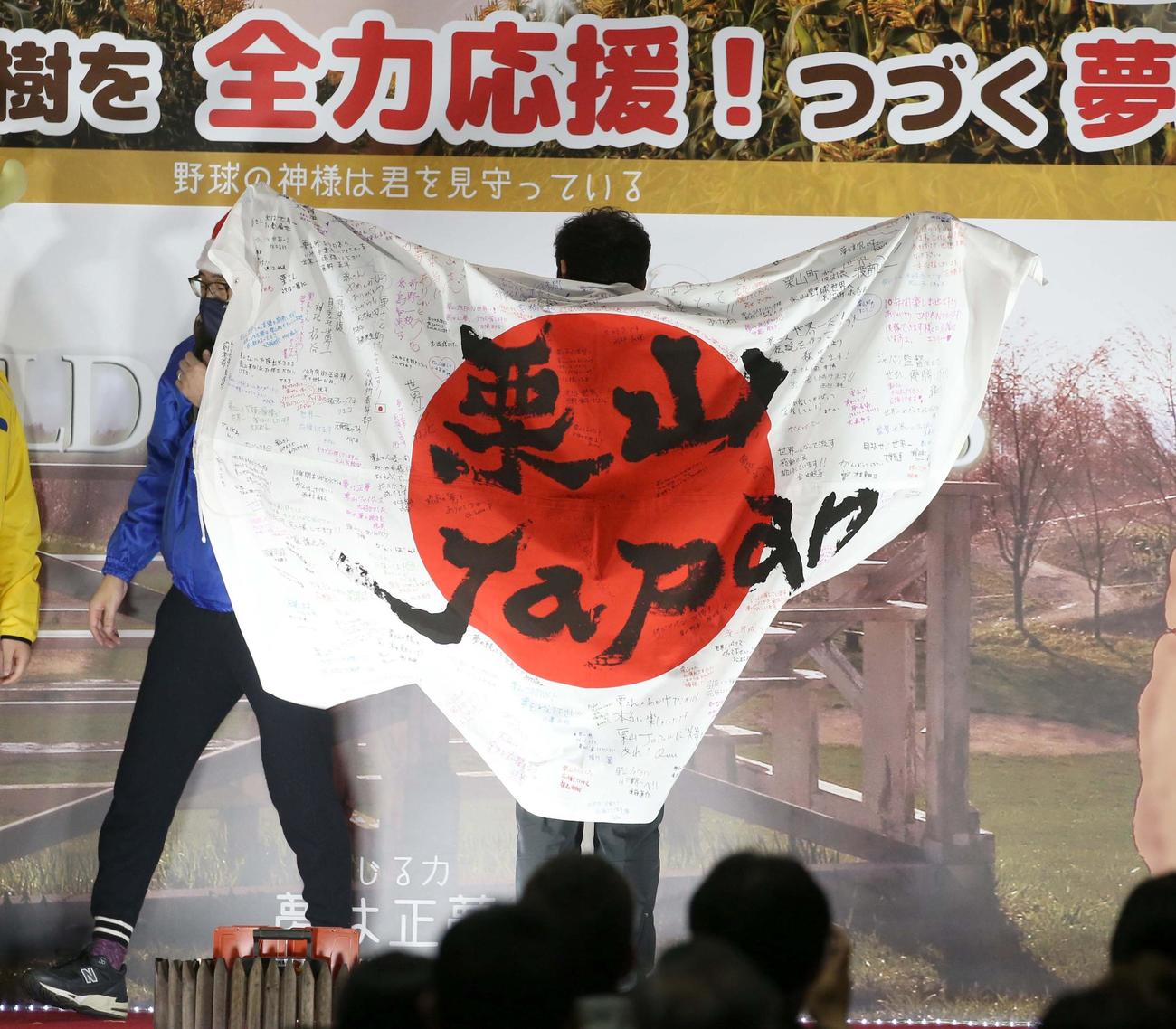 栗山町で行われた「栗さん感謝のつどい」で町民などから贈られた日の丸を羽織る栗山監督（撮影・黒川智章）