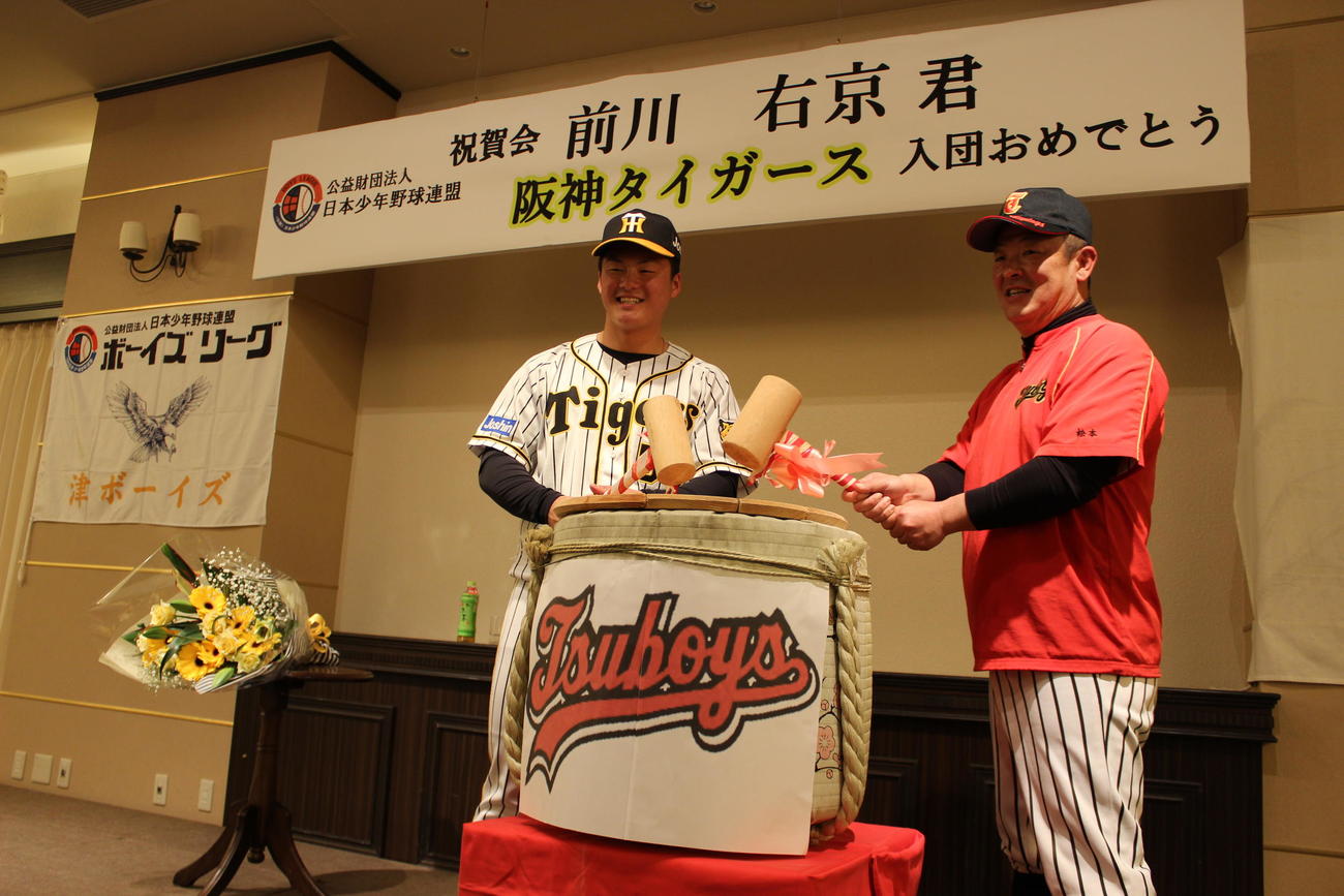 津ボーイズの激励会で鏡開きをする阪神前川。右は松本直也監督（撮影・柏原誠）
