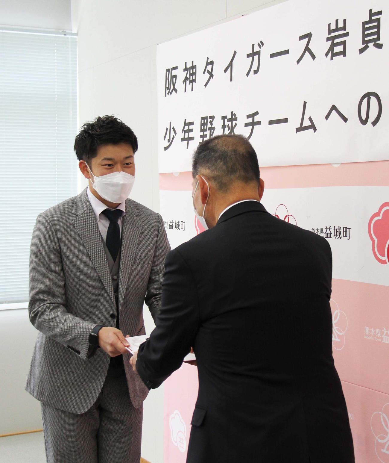 熊本県の西村益城町長（右）から目録を受け取る阪神岩貞（益城町提供）