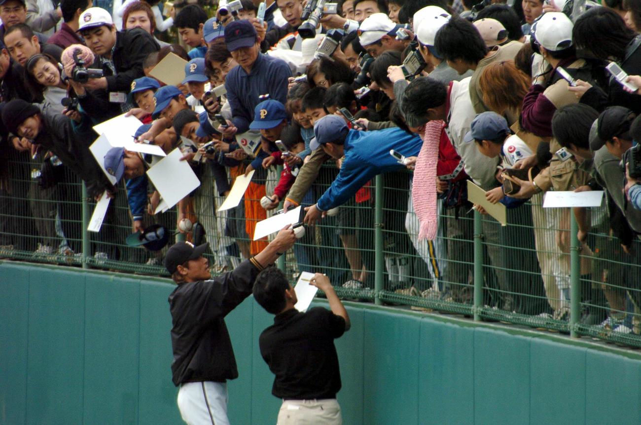 日本ハム春季キャンプ　フェンスが壊れそう！クールダウンを終えた新庄は集まったファンに気軽にサインする（2004年2月1日撮影）