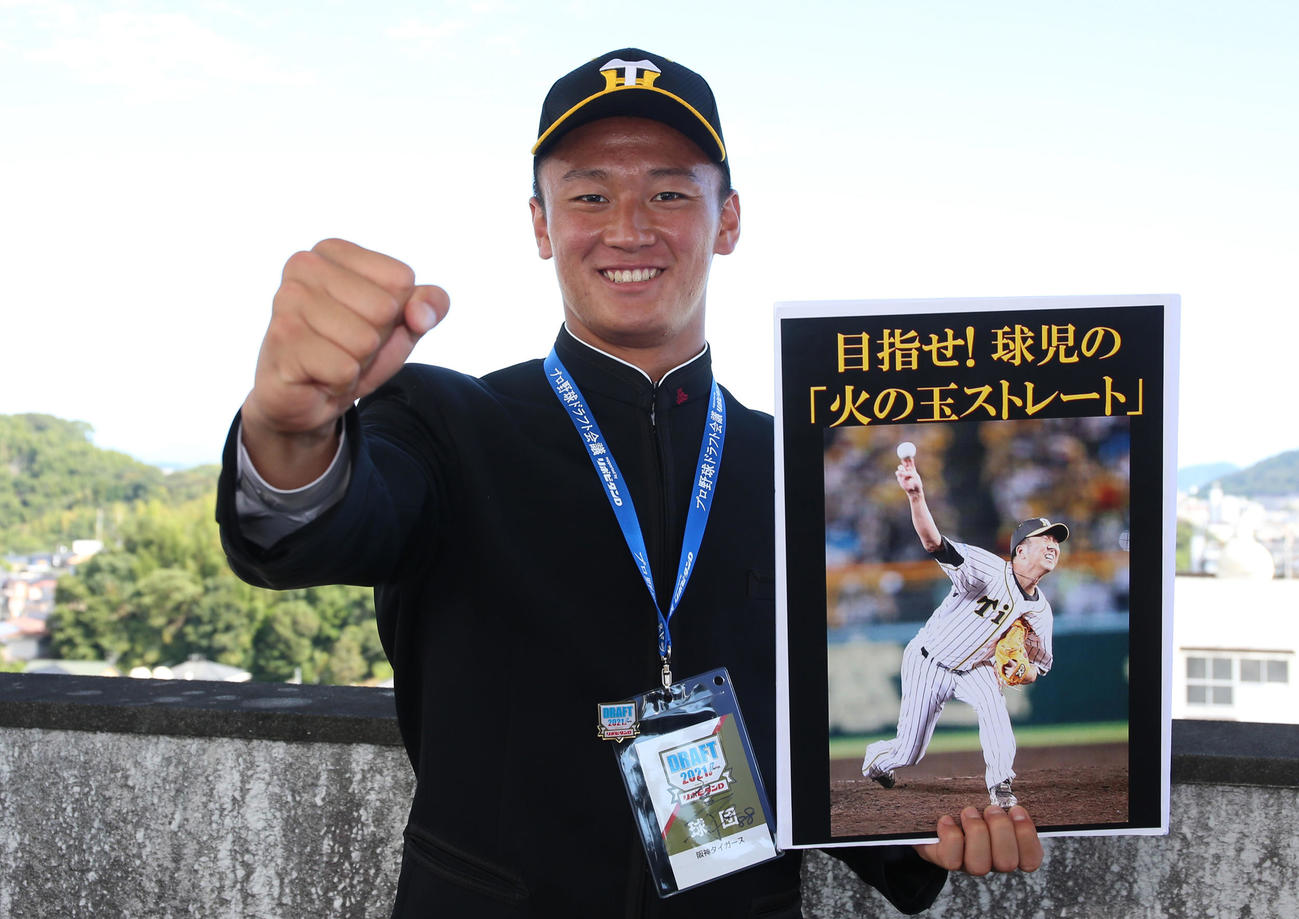 10月12日、阪神から指名あいさつを受けた高知・森木は藤川氏の写真パネルを持って笑顔を見せる