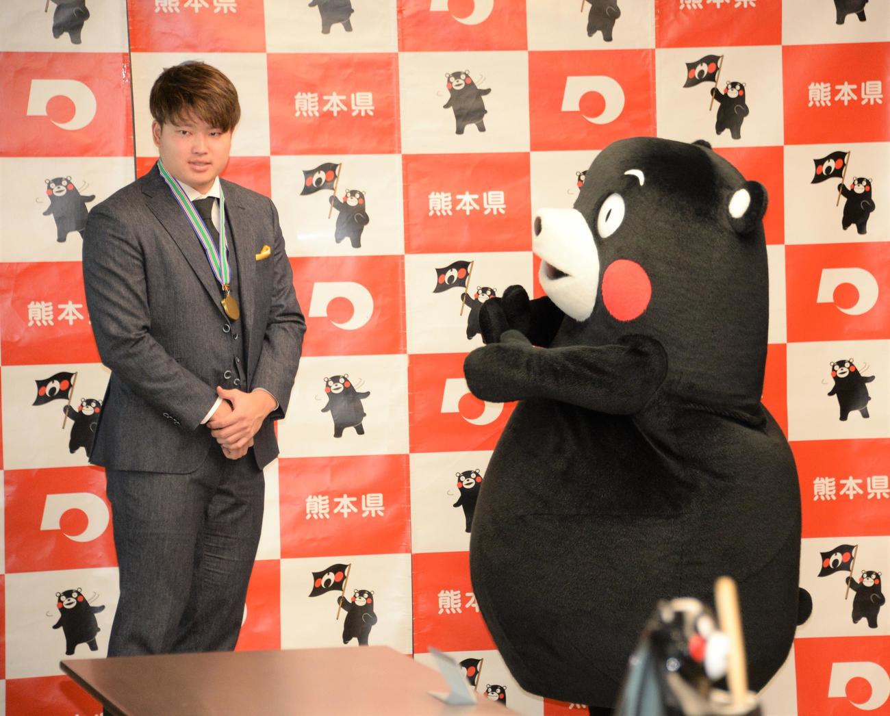 「くまもと夢づくり賞」を受賞したヤクルト村上は、くまモンから特製の金メダルを授与される（撮影・鈴木正章）