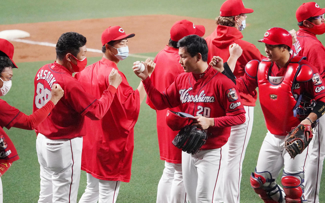 10月7日の中日戦で30セーブを達成し佐々岡監督らナインとタッチをかわす広島栗林（中央）