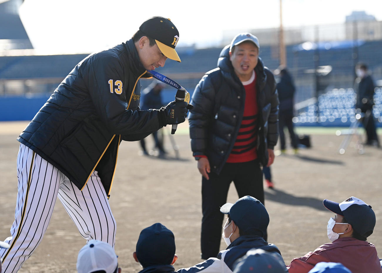 プロ野球静岡県人会のトークショーで東京オリンピックの金メダルを披露する阪神岩崎（撮影・前岡正明）