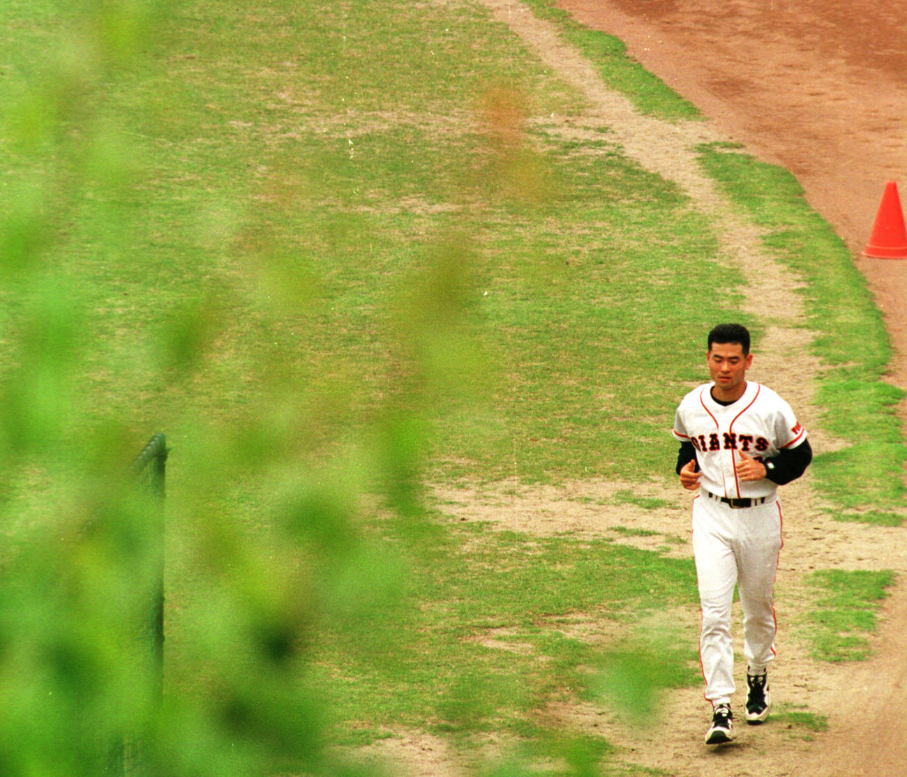96年6月、右ひじ手術後のリハビリを兼ねて外野フェンス際をランニングする桑田。芝生がはげた部分は「桑田ロード」と呼ばれるようになった