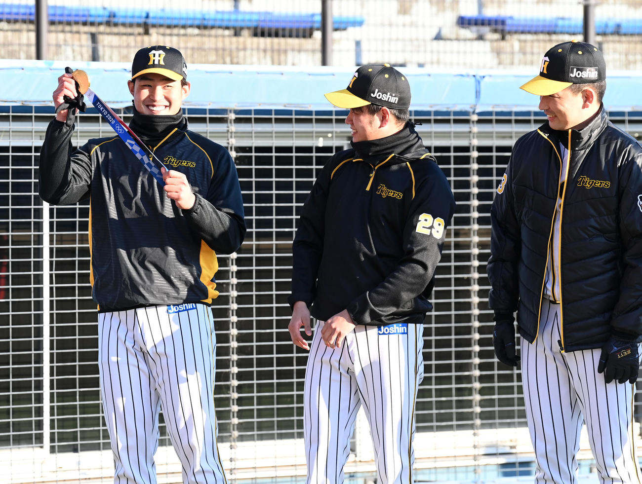 プロ野球静岡県人会で阪神岩崎（右）の東京オリンピック金メダルを手に笑顔を見せる佐藤蓮（左）。中央は高橋（撮影・前岡正明）