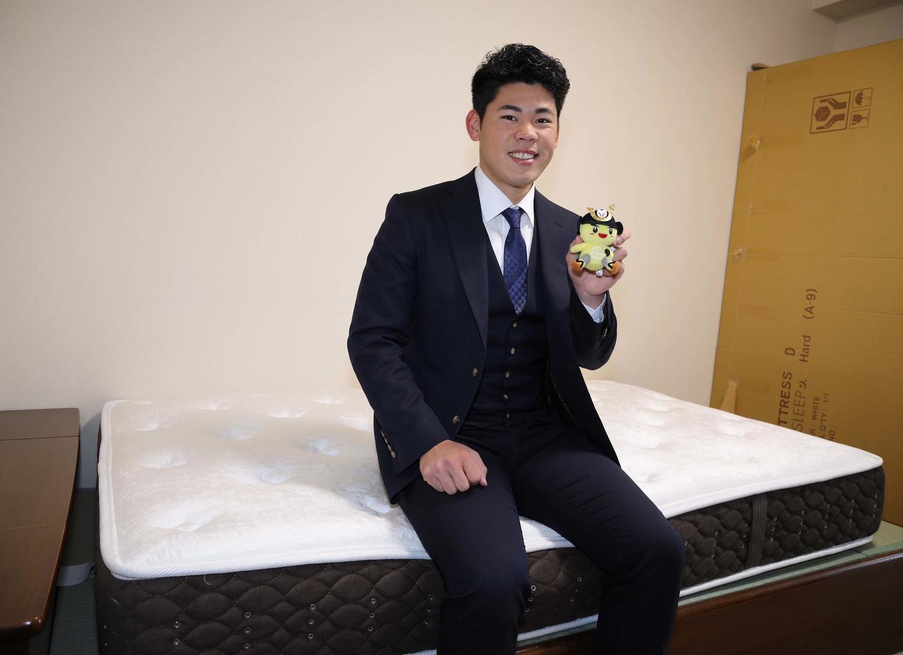 地元鹿児島県日置市のイメージキャラクター「ひお吉くん」のぬいぐるみを手に笑顔を見せる阪神ドラ2の鈴木（球団提供）