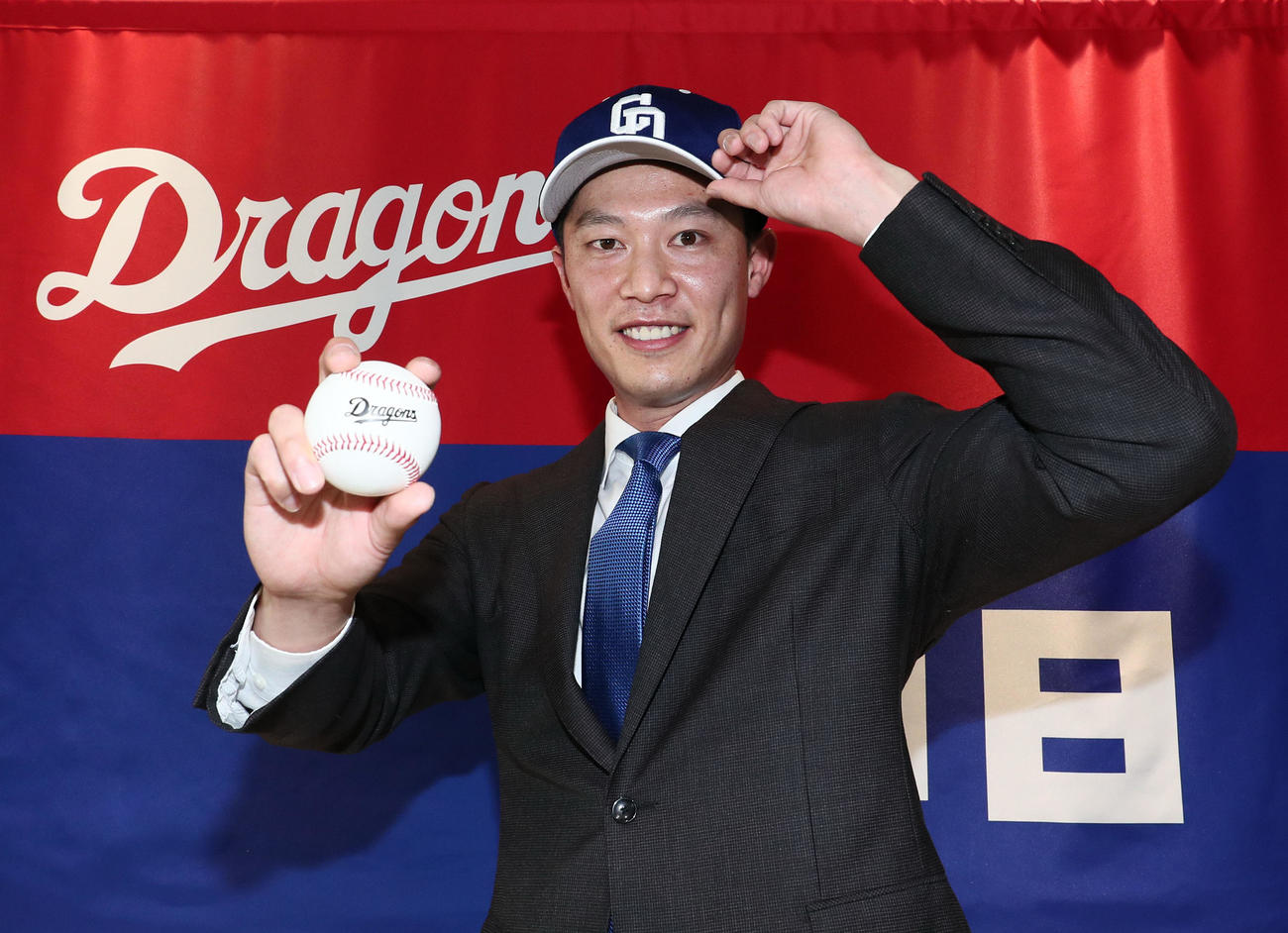 会見後、球団旗の前でポーズを決める岩崎翔（代表撮影）