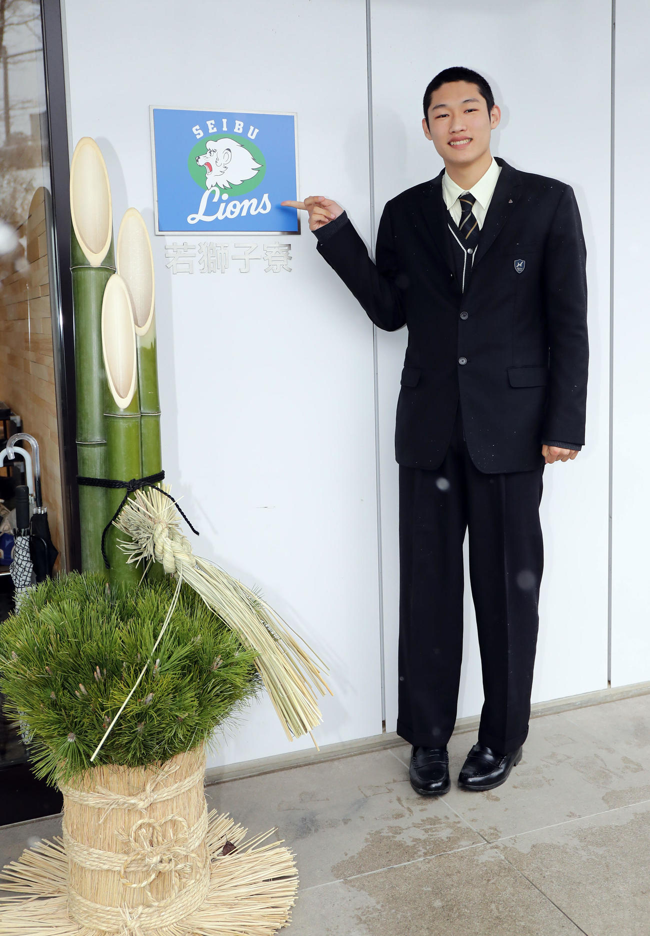 若獅子寮に入寮した西武ドラフト4位の羽田は、玄関のプレートを指差し笑顔（撮影・浅見桂子）