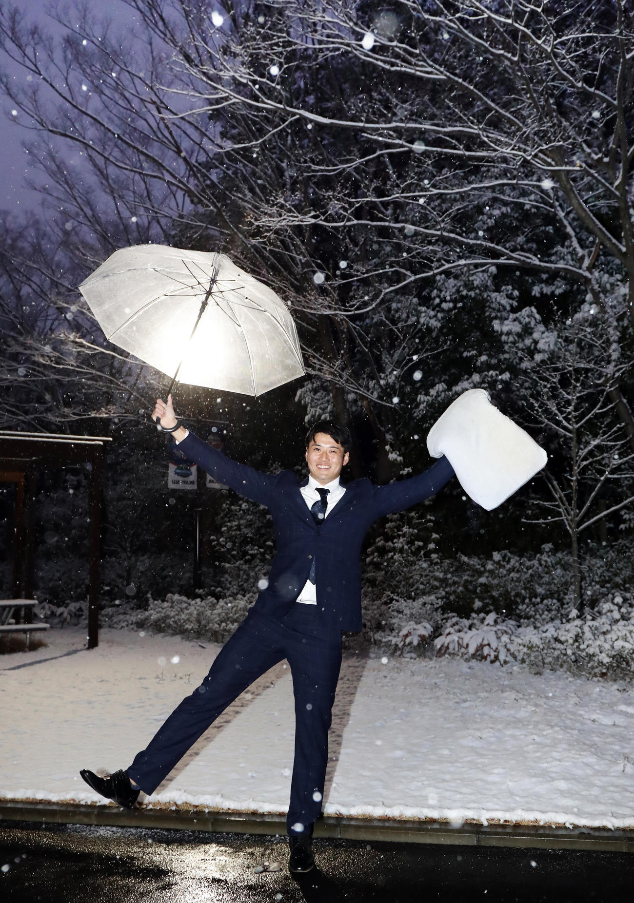 入寮した西武ドラフト2位の佐藤は、持参した枕をを手に積もった雪を背にしてバンザイ（撮影・浅見桂子）