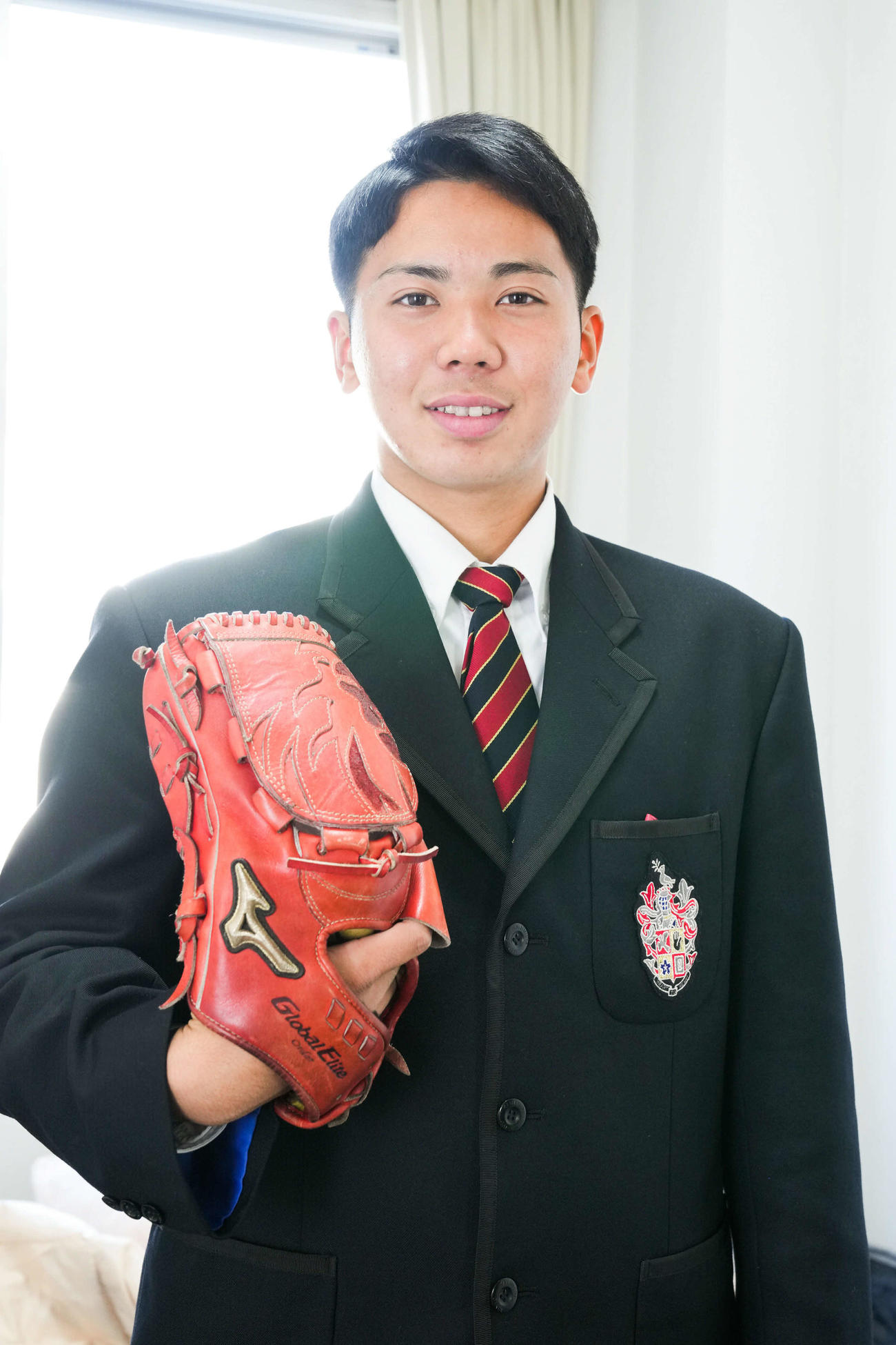入寮した楽天ドラフト4位の神村学園高・泰は持ち込んだグラブを手にする（楽天野球団提供）