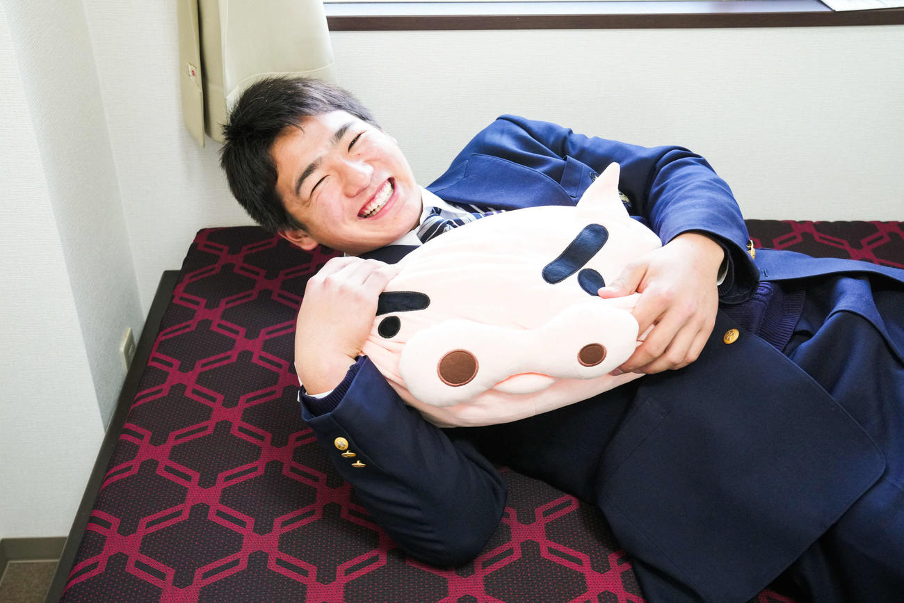 入寮した楽天ドラフト3位の三島南高・前田はアニメ「クレヨンしんちゃん」のキャラクター「ぶりぶりざえもん」のクッションを手に笑顔（楽天野球団提供）
