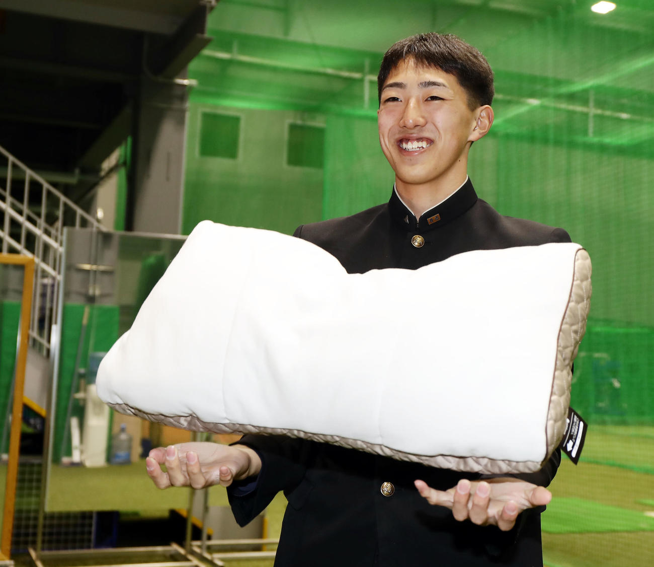若獅子寮に入寮した西武ドラフト5位の黒田は、持参した枕を、出身地青森の大間のマグロに例えて笑顔で持つ（撮影・浅見桂子）