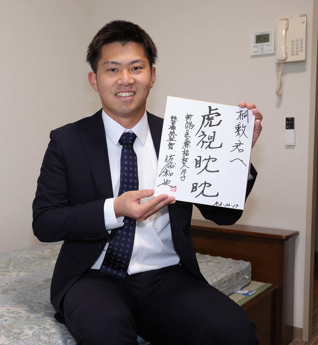 新潟医療福祉大野球部・佐藤総監督から贈られた色紙を持ち込んだ桐敷（球団提供）