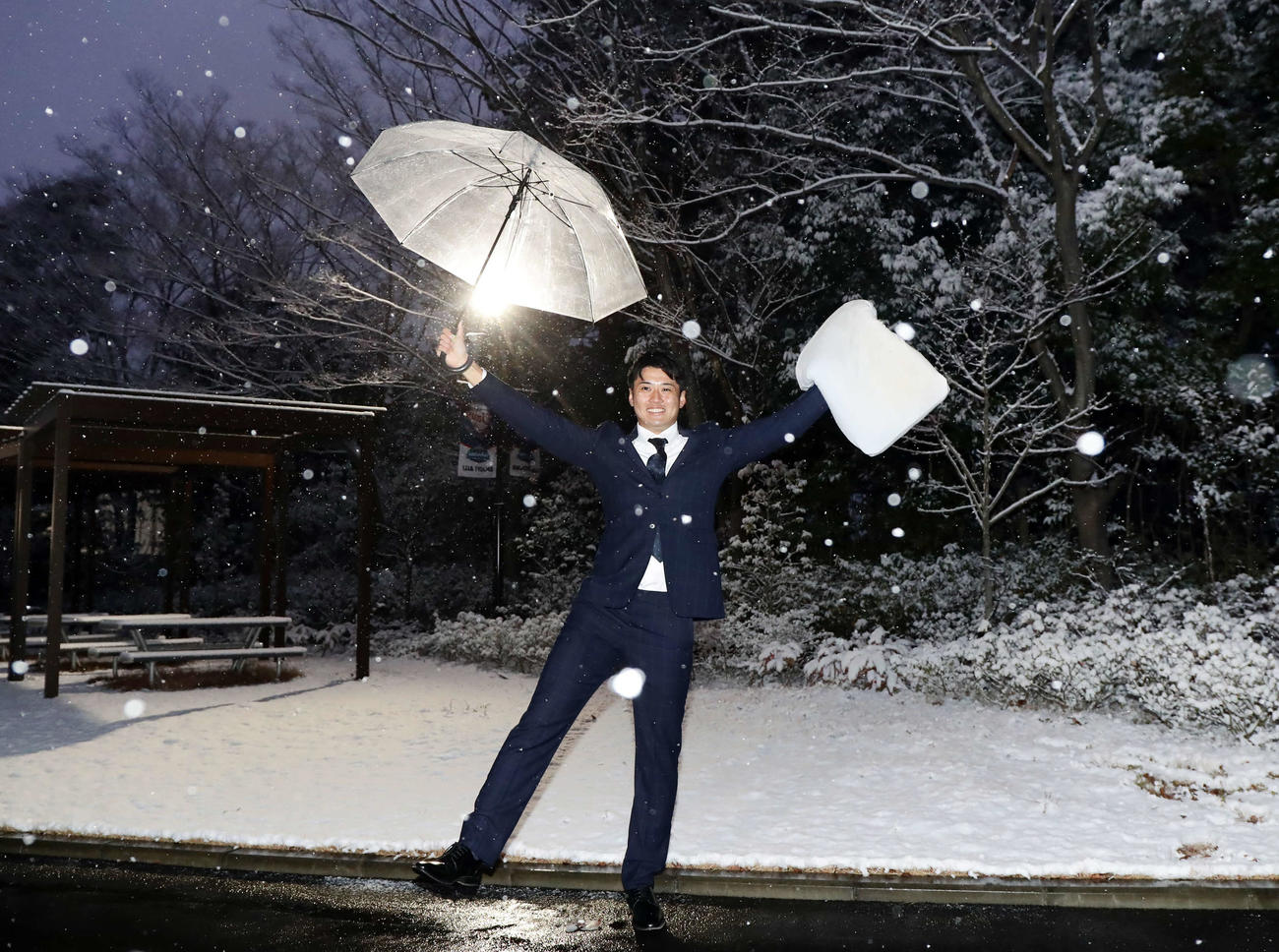 入寮した西武ドラフト2位の佐藤は、持参した枕を手に、積もった雪を背にしてバンザイ（2022年1月6日撮影）