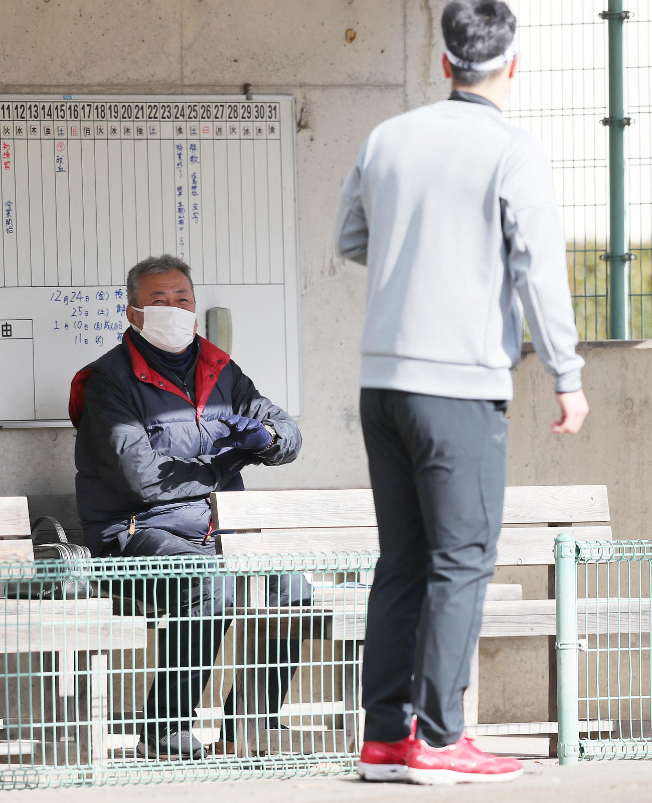 近大のグラウンドで自主トレする阪神佐藤輝（右）に声を掛ける近大・田中監督（撮影・前田充）