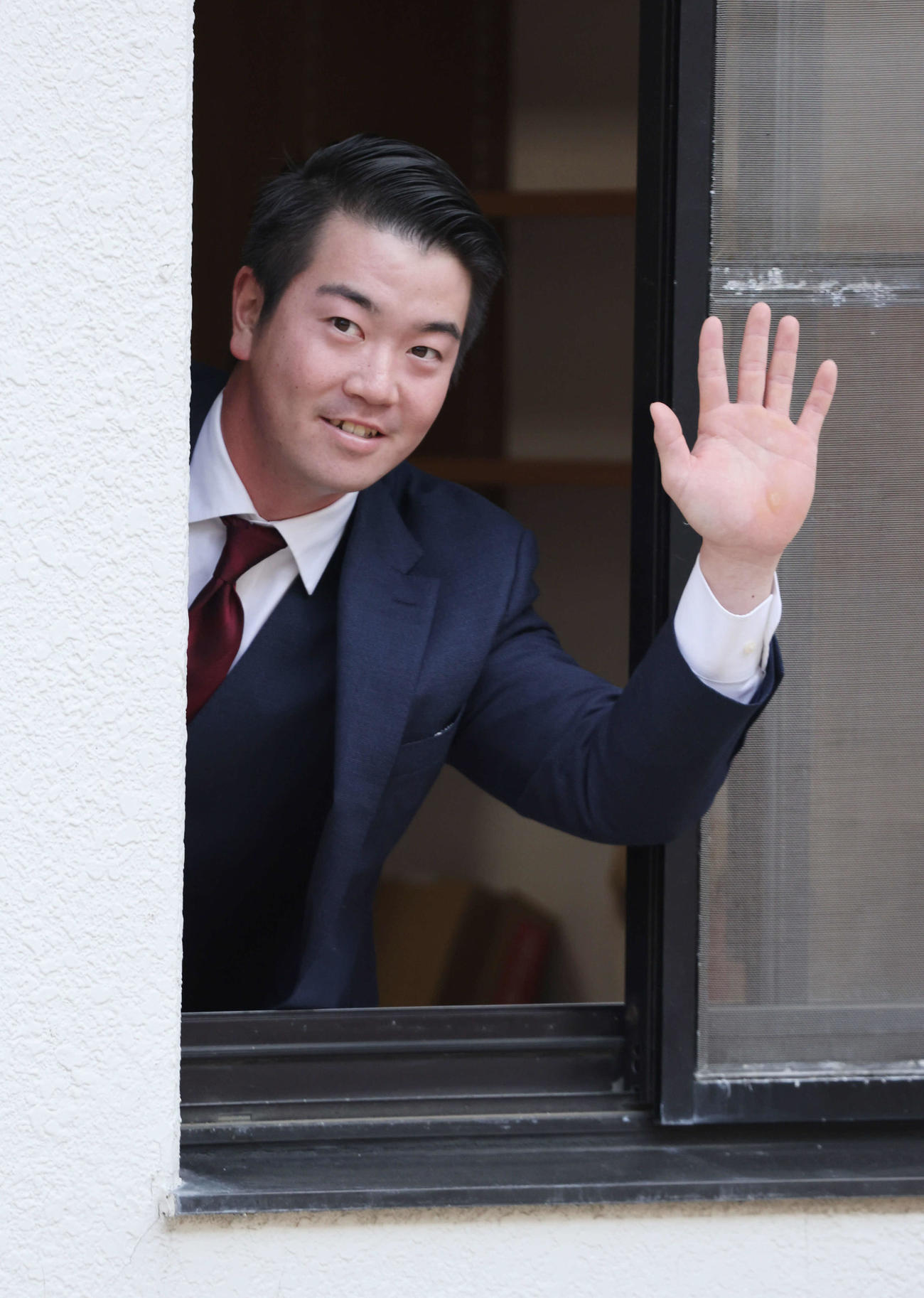 入寮し、窓から手を振る広島ドラフト3位の中村健（撮影・加藤孝規）