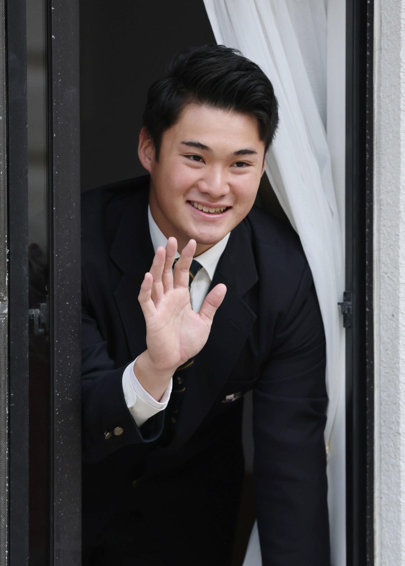 入寮し、窓から手を振る広島ドラフト4位の田村（撮影・加藤孝規）