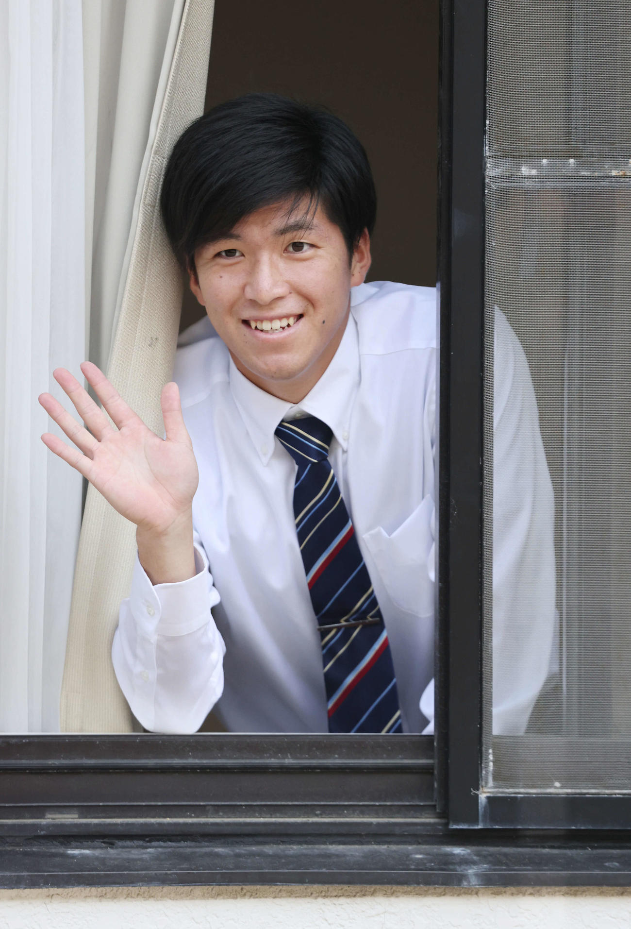入寮し、窓から手を振る広島ドラフト1位の黒原（撮影・加藤孝規）