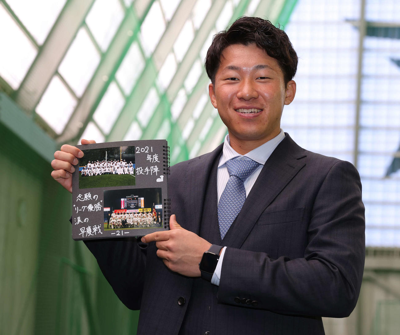 入寮を終え早大の後輩が作成したアルバムを手に笑顔で記念撮影に納まるDeNAドラフト2位の徳山（撮影・河野匠）