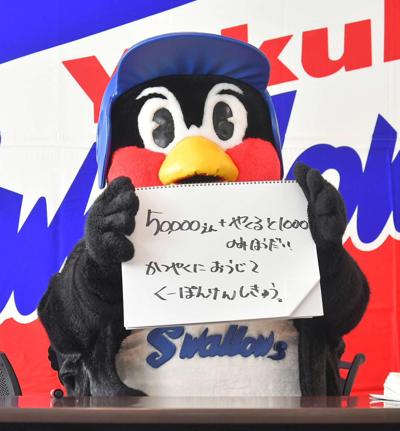会見するつば九郎。「50000えん＋やくると1000のみほうだい　かつやくにおうじてくーぽんけんしきゅう。」（代表撮影）