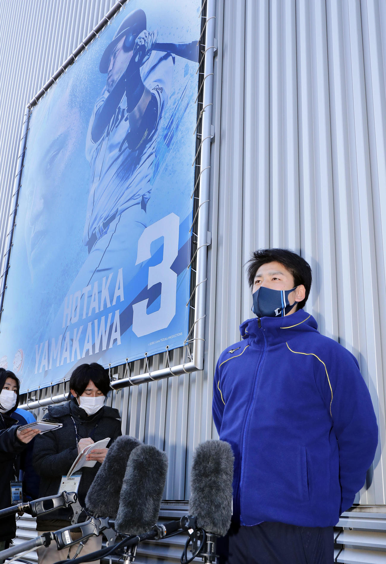 新人合同自主トレ初日を終えて、山川の看板を背に報道陣の質問に答える西武隅田（撮影・浅見桂子）