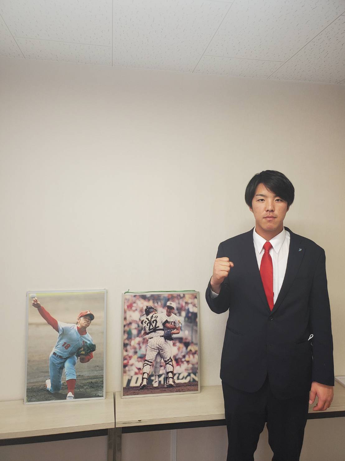 奈良学園大の三好辰弥外野手は同校OBの元中日山井大介氏、元阪神湯舟敏郎氏のパネルの前でガッツポーズした