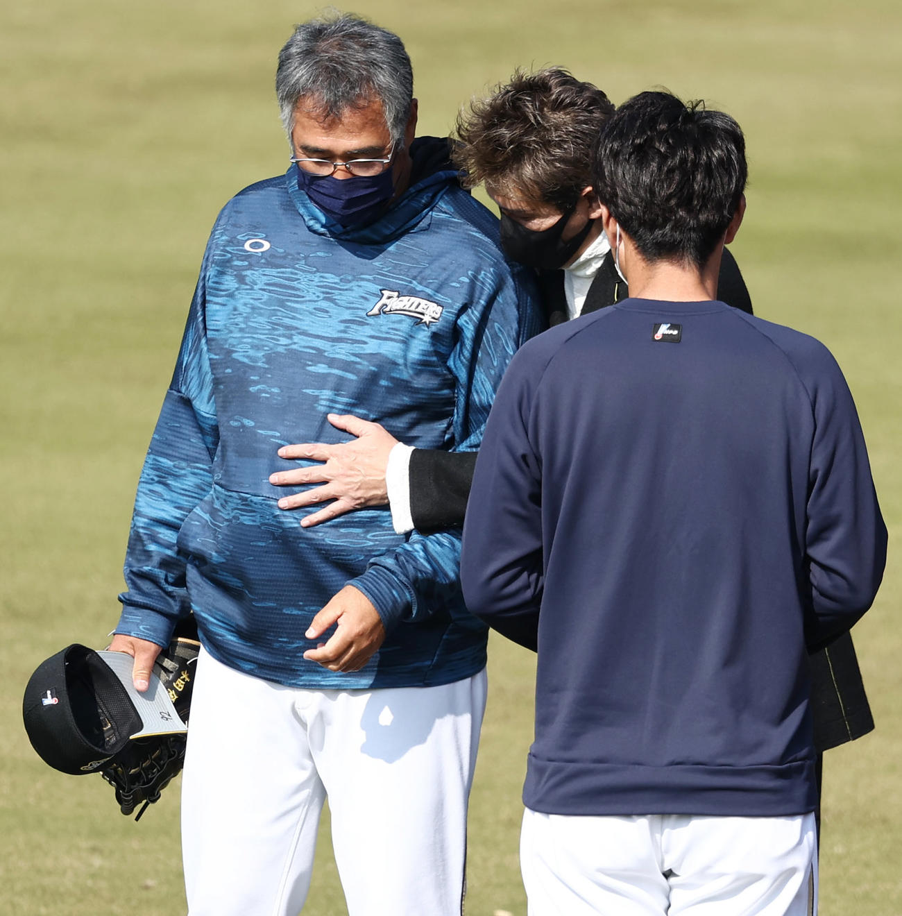 練習中、日本ハム新庄監督（中央）は木田2軍監督（左）との談笑中に腹を触る（2021年11月20日撮影）