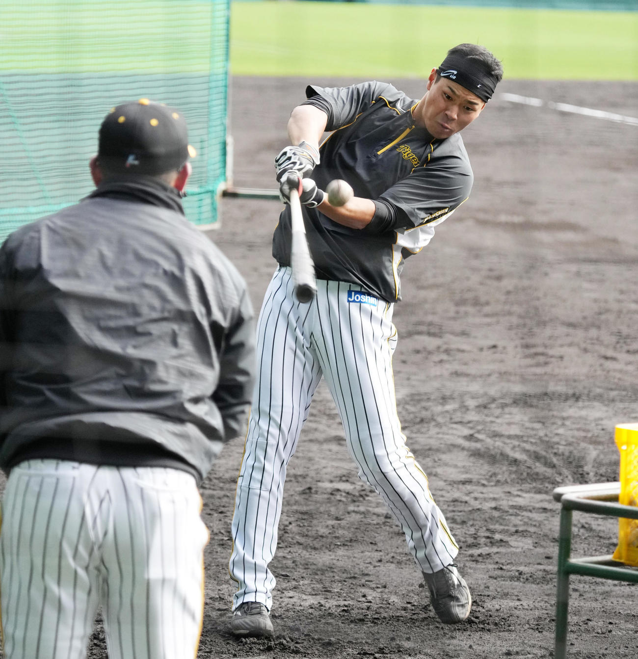 阪神北川打撃コーチ（手前）から3連続の短い間隔でのトスを打つ佐藤輝（撮影・清水貴仁）