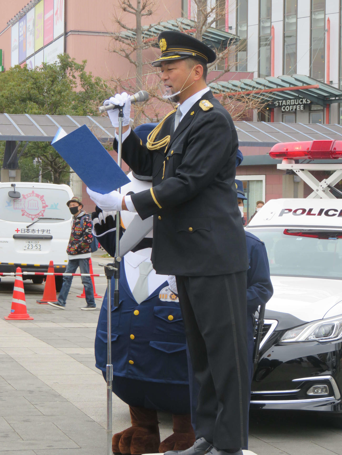 一日警察署長として、110番通報の正しい利用を通行人にお願いするDeNA斎藤チーフ投手コーチ