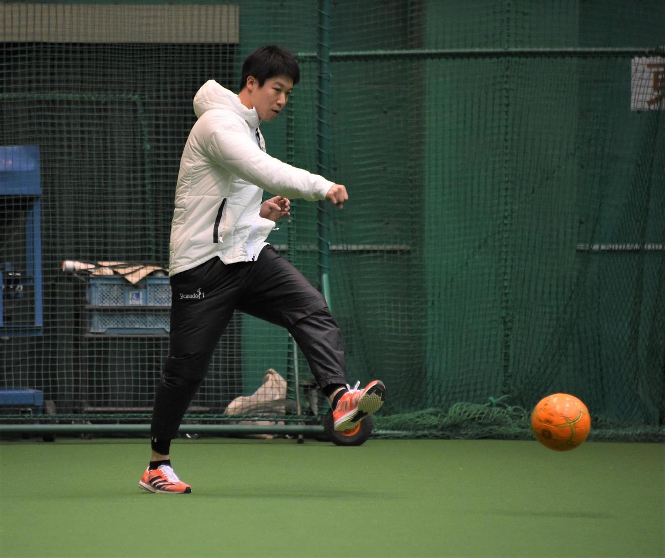 合同自主トレでサッカーボールを蹴るヤクルト山田（撮影・鈴木正章）