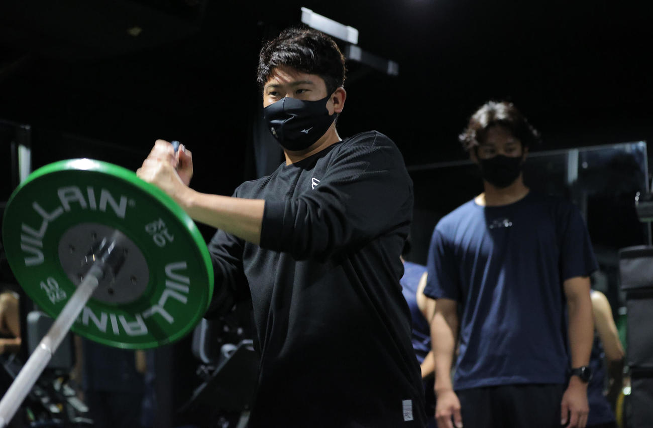 ウエートトレーニングを行う巨人菅野。後方は阪神藤浪（球団提供）