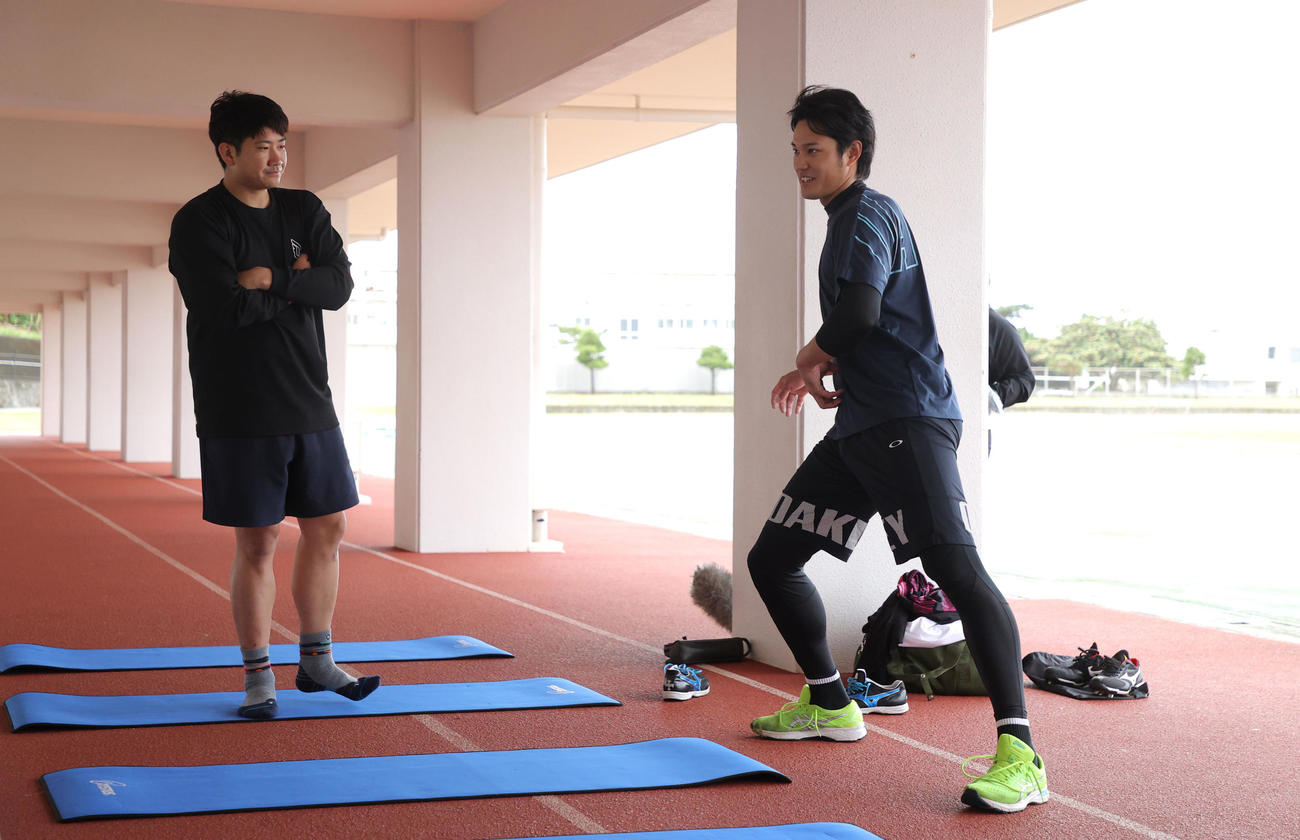 自主トレで阪神藤浪（右）の質問に答える巨人菅野（球団提供）