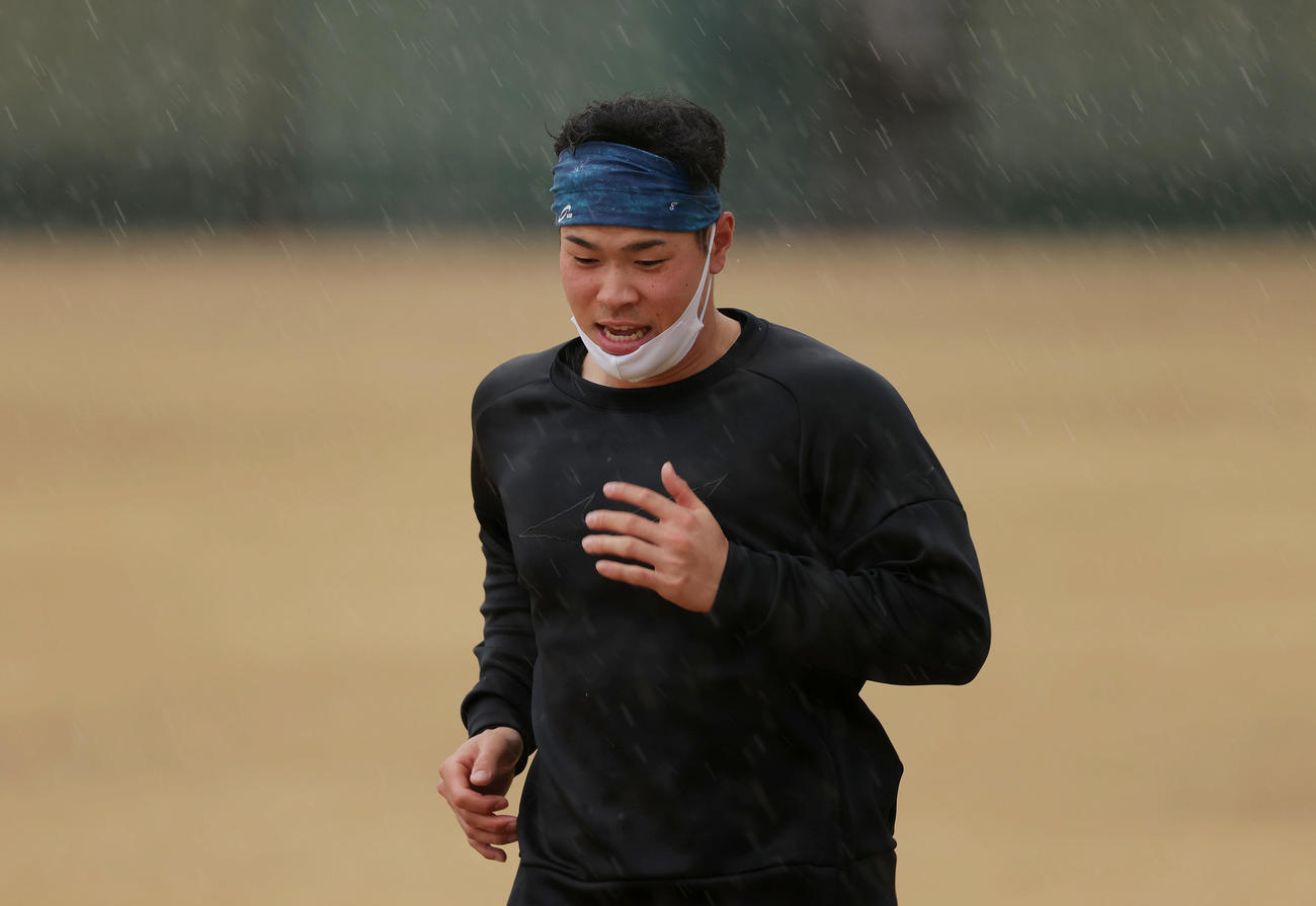 雨が降る中、外野でダッシュを繰り返す阪神佐藤輝（撮影・前田充）