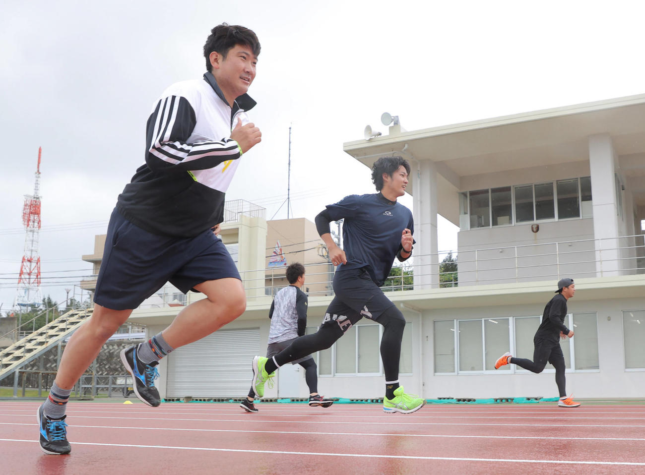 自主トレでダッシュをする、左から巨人菅野（手前）と阪神藤浪（球団提供）