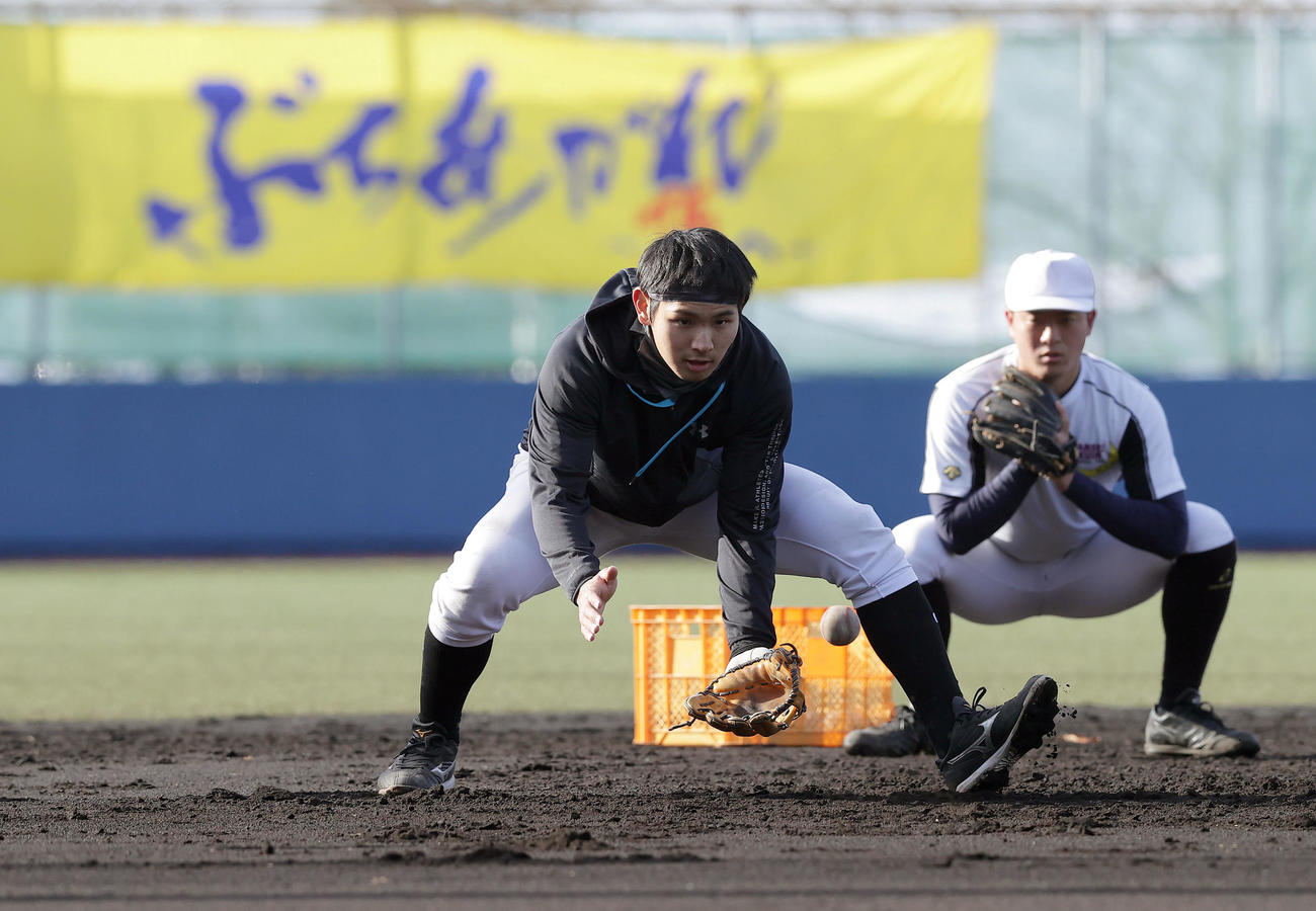 三塁でノックを受ける関学大・佐藤太紀（左）（撮影・前田充）