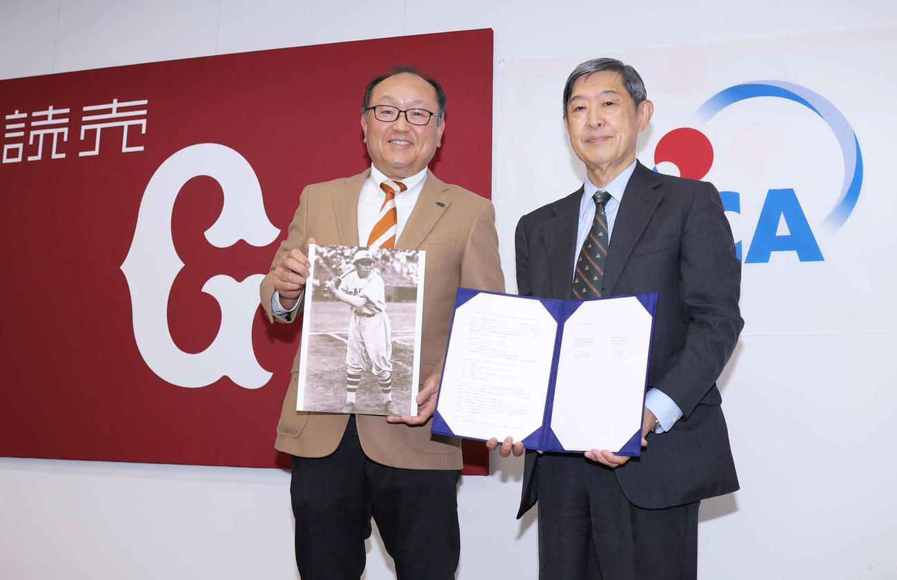 巨人今村代表取締役社長（左）は、フィリピン出身の元巨人アデラーノ・リベラさんの写真を手にJICA北岡理事長と写真に納まる（撮影・河田真司）