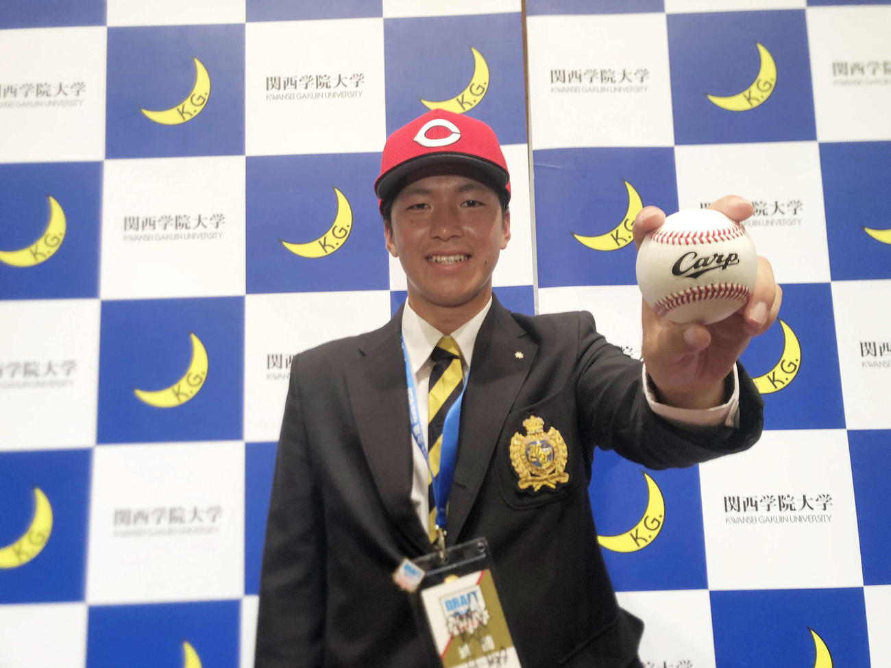 カープ帽子をかぶり、「Carp」の文字が刻印された球を握るドラフト1位関学大・黒原拓未投手（2021年10月19日撮影）