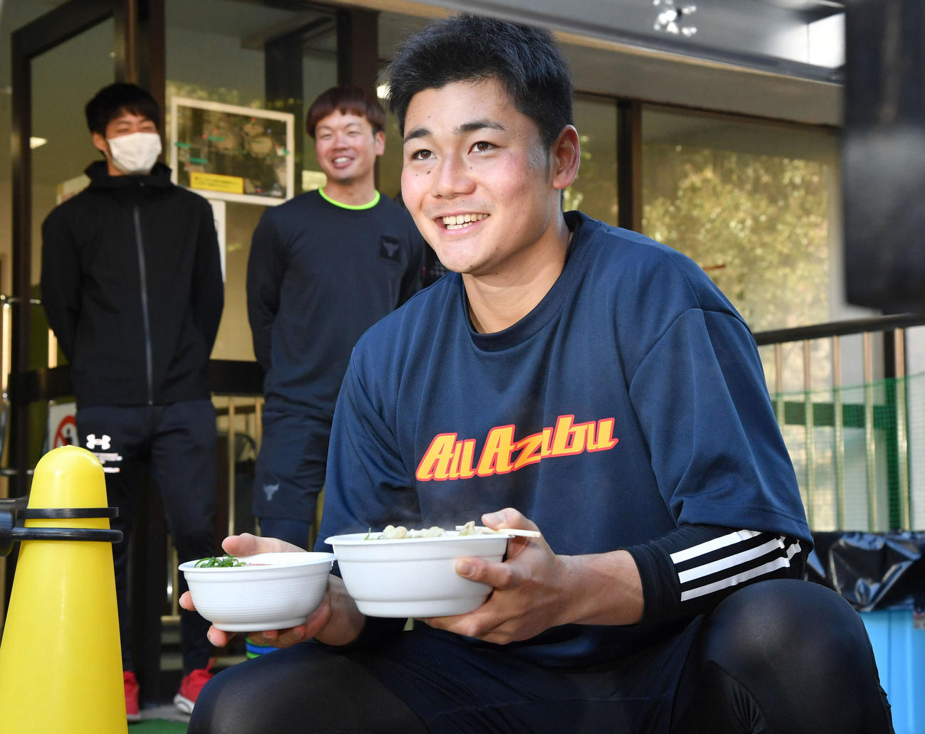 午前中の練習を終え、ソフトバンク柳田が差し入れしたうどんと丼を手に笑顔を見せる清宮（撮影・岩下翔太）