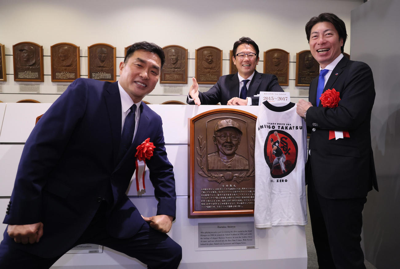 古田氏（中央）のレリーフの前で記念撮影する山本氏（左）と大リーグ時代のTシャツを手にするヤクルト高津監督（代表撮影）