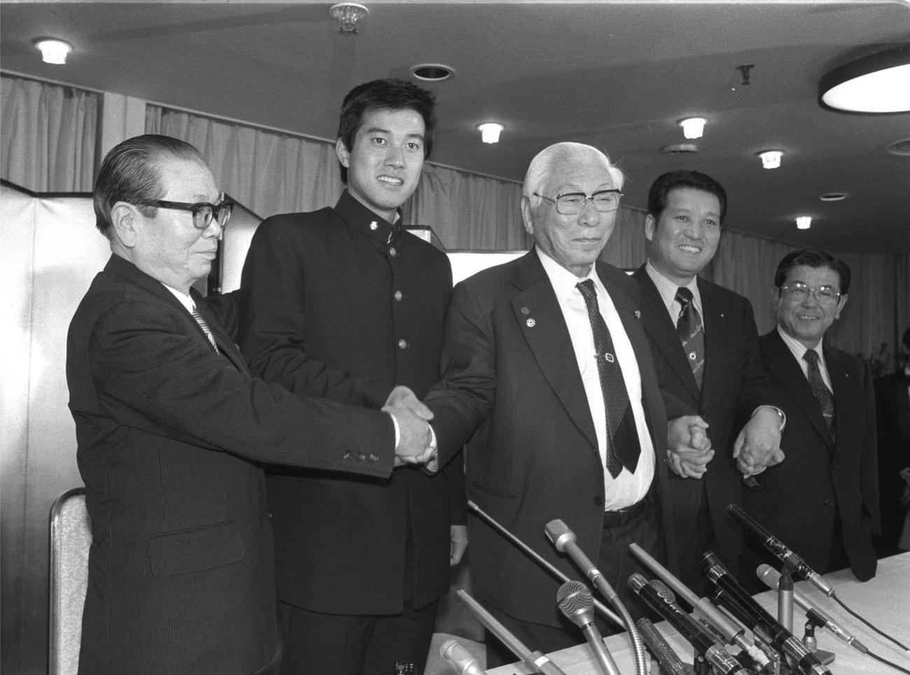 巨人と正式契約をし、記者会見する左から長谷川巨人球団代表、原辰徳、松前東海大学総長、原貢氏（1980年12月）