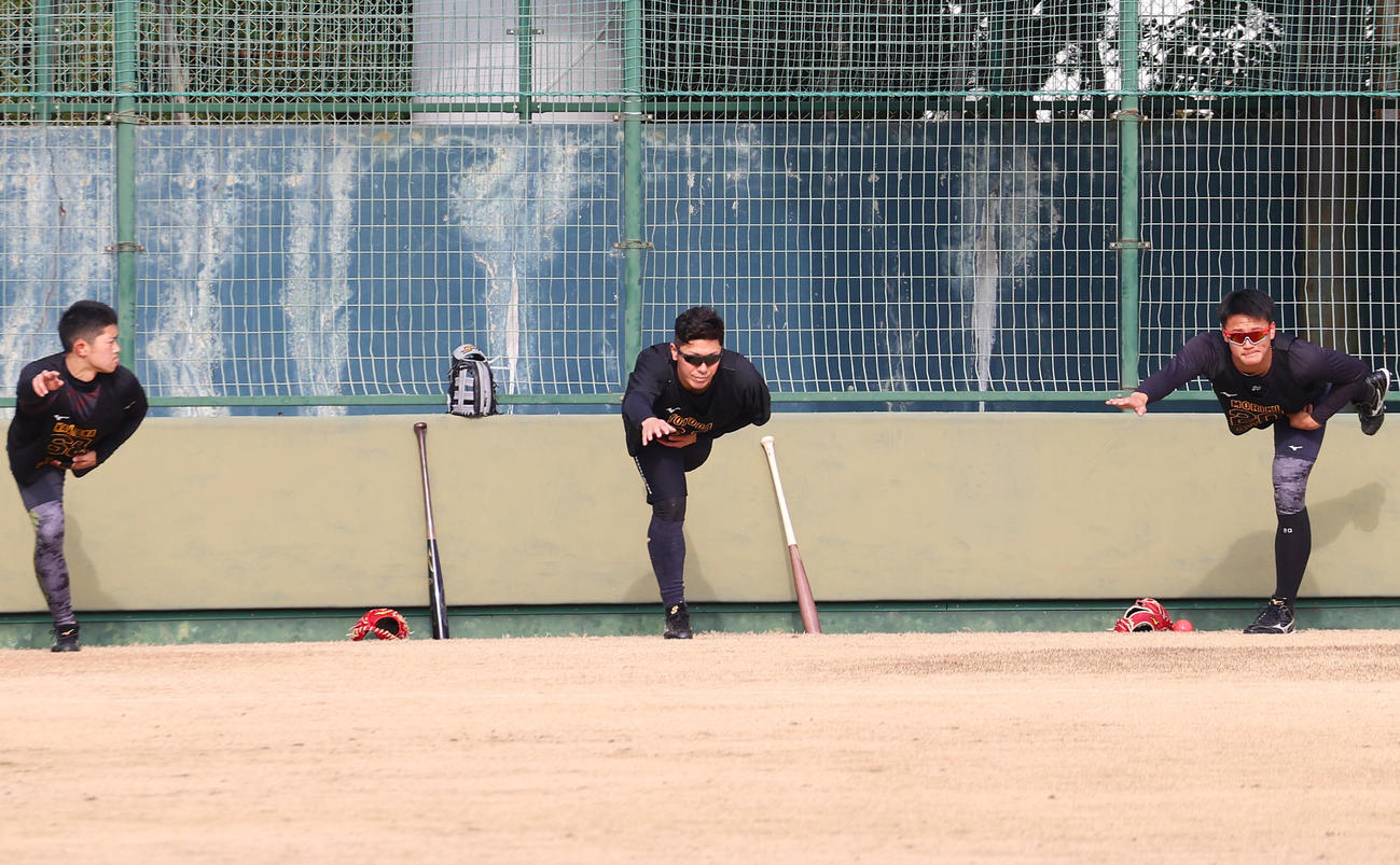 新人合同自主トレで柔軟する豊田。左は中川、右は森木（撮影・上山淳一）