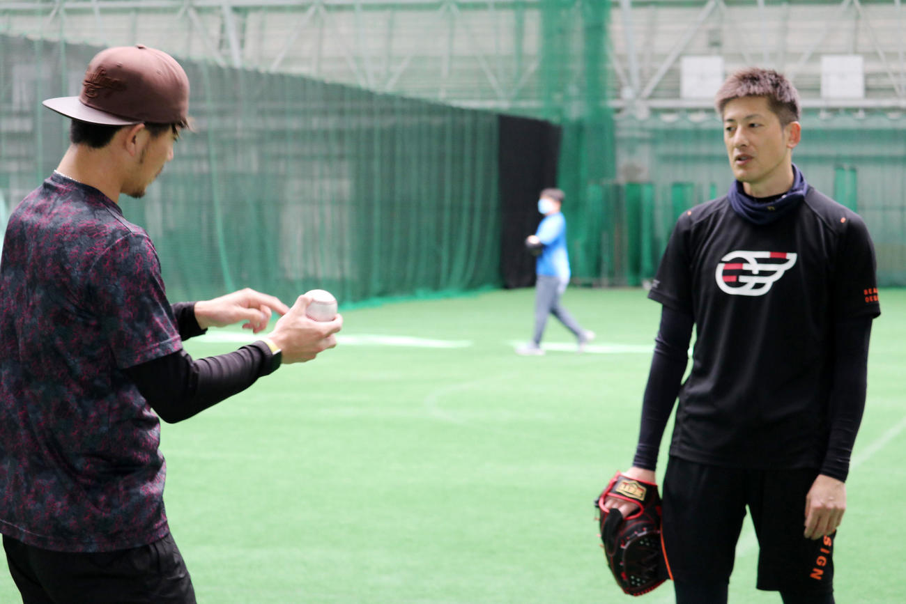 自主トレを公開しオリックス能見（右）と話し合う伊藤将（球団提供）