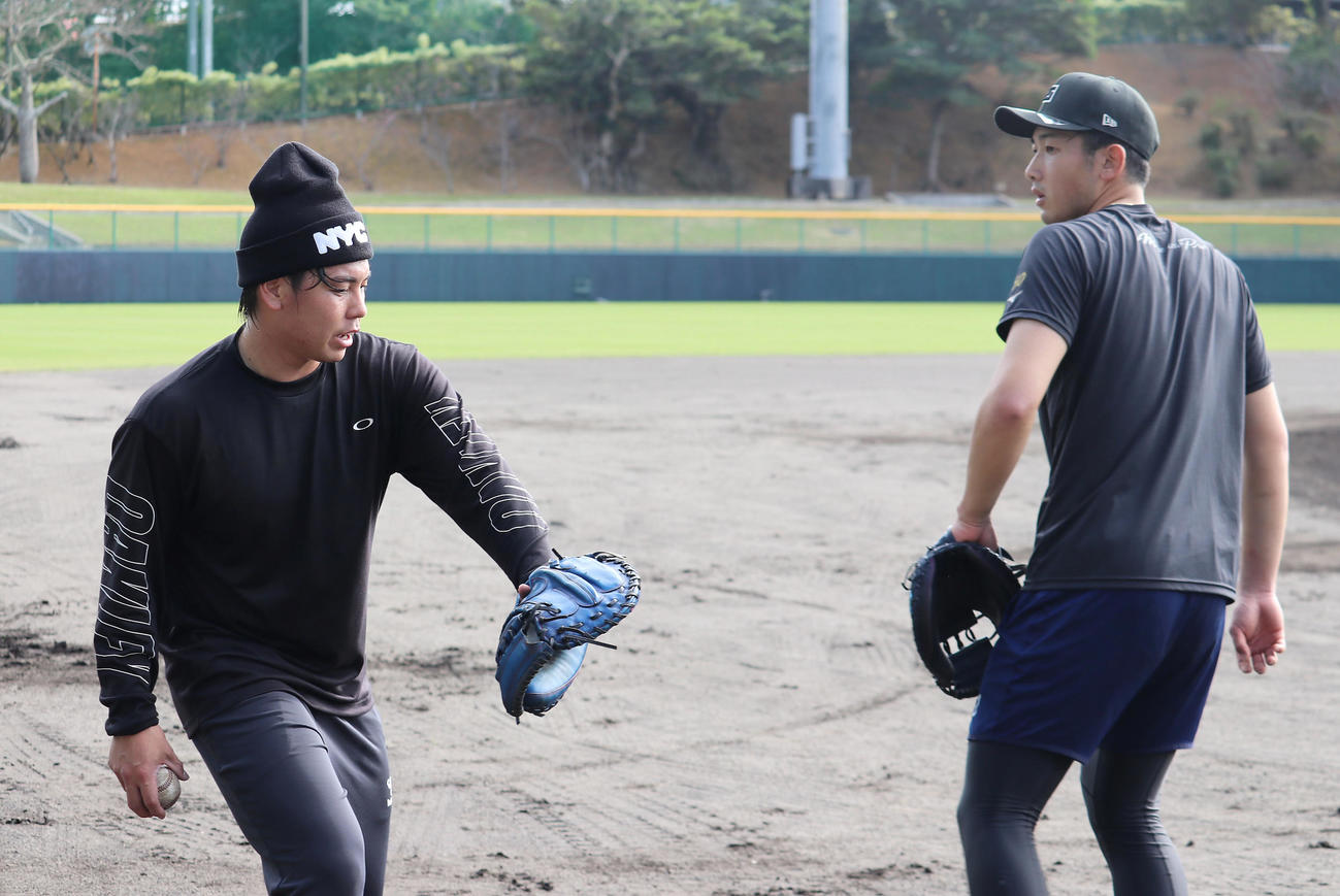 宜野座で合同自主トレを行う阪神梅野（左）とDeNA山本（球団提供）