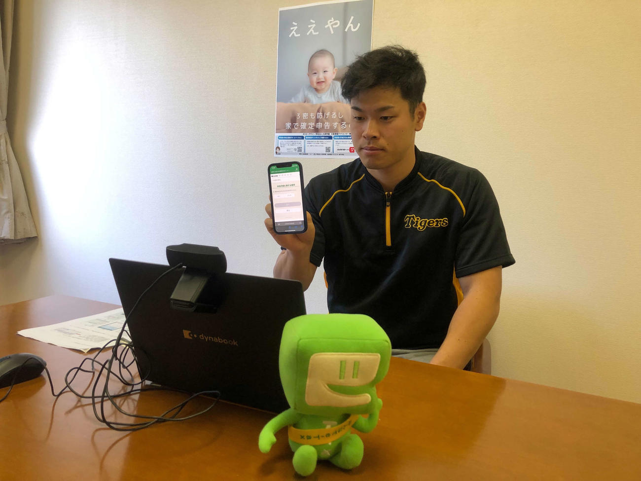 e－Taxを利用したスマホで確定申告のPRをする阪神佐藤輝（球団提供）
