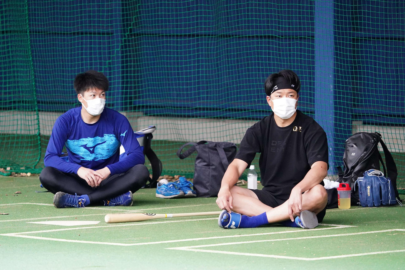 北谷球場ブルペンで大野雄（右）と会話する中日橋本（球団提供）