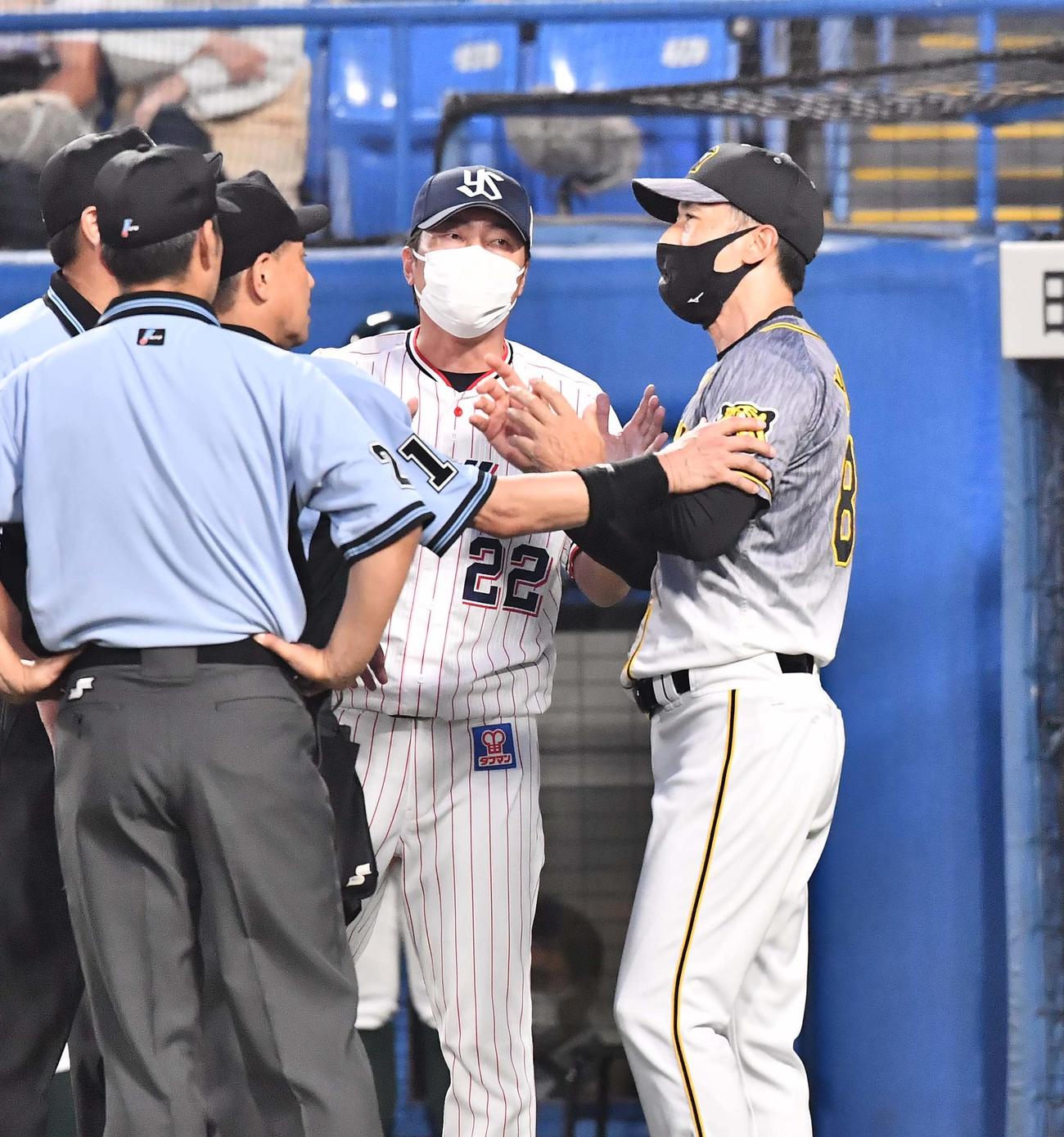 ヤクルト対阪神　5回、話し合う高津監督（右から2人目）と矢野監督（右端）（2021年7月6日撮影）